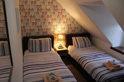 two beds in a attic room with a lamp at Islay Frigate Hotel in Tarbert