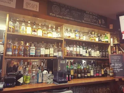 a bar filled with lots of bottles of alcohol at Islay Frigate Hotel in Tarbert