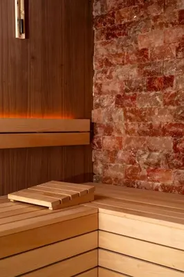 a sauna with wooden floors and a brick wall at The Address Glasgow in Glasgow