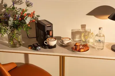 a table with a coffee maker and a plate of food at The Address Glasgow in Glasgow