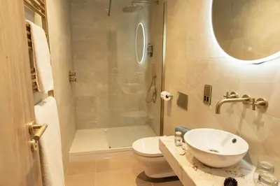a bathroom with a sink and a toilet and a shower at The Address Glasgow in Glasgow