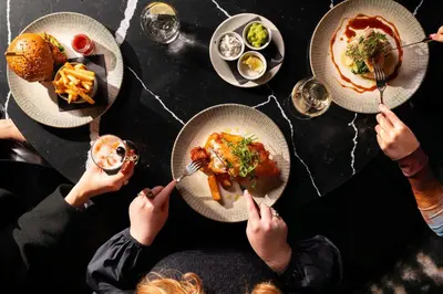a group of people sitting at a table eating food at The Address Glasgow in Glasgow