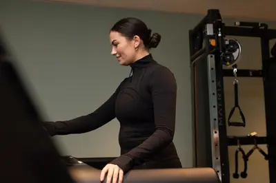 a woman in a gym sitting in a pilates apparatus at The Address Glasgow in Glasgow