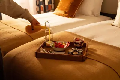 a tray of food on the edge of a bed at The Address Glasgow in Glasgow
