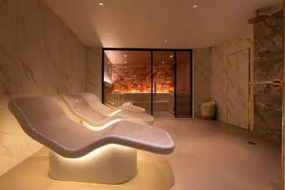a white chair in a room with a fireplace at The Address Glasgow in Glasgow