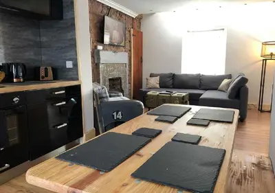 a living room with a table and a couch at Fisher Holiday Cottage Ayrshire in Girvan