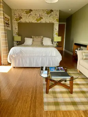 a bedroom with a bed and a table with a laptop at Aspen Lodge in Oban