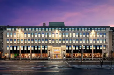 a large building with lights on in a parking lot at YOTEL Edinburgh in Edinburgh