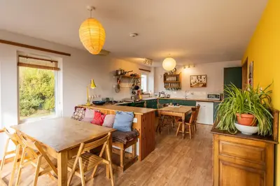 a kitchen with a table and a dining room at Shorefield, Bruichladdich in Bruichladdich