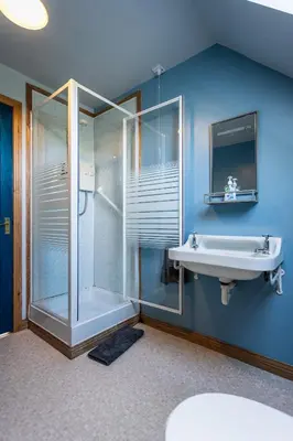 a bathroom with a glass shower and a sink at Shorefield, Bruichladdich in Bruichladdich