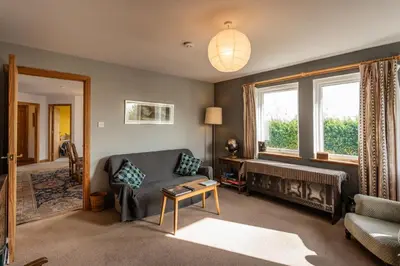 a living room with a couch and a table at Shorefield, Bruichladdich in Bruichladdich