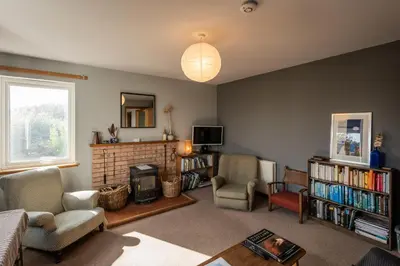 a living room with a couch and chairs and a fireplace at Shorefield, Bruichladdich in Bruichladdich
