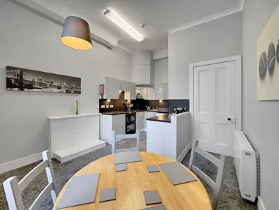a kitchen with a table and chairs in a room at Hayfield Apartment in Oban