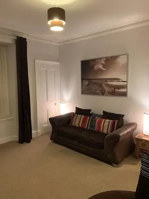 a living room with a brown couch in a room at Apartment 39c in Oban