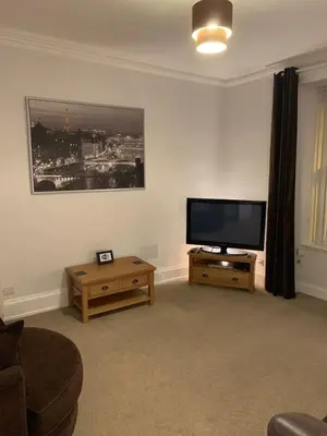 a living room with a flat screen tv and a couch at Apartment 39c in Oban