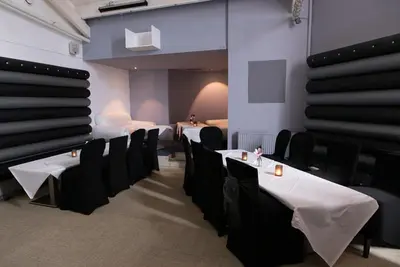 a dining room with white tables and black chairs at Livingston Lodge Hotel in Livingston
