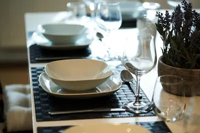 a table with a bowl and plates and wine glasses at Thornhill Lodge, Historic 4 Bed, 4 Ensuite in Stirling