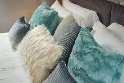 a bunch of pillows on a bed at Stuc an t Sagairt Cottage , Loch Lomond in Drymen