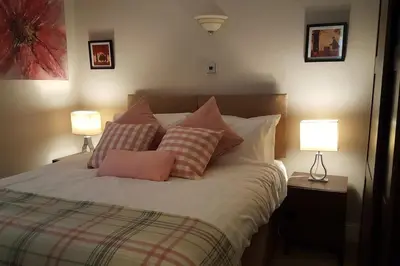 a bedroom with a bed with pillows and two lamps at Thornhill House - Historic 5 Bedroom 5 Ensuite in Stirling