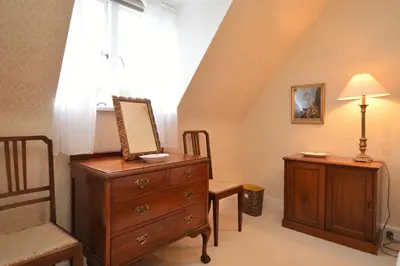 a bedroom with a dresser and a chair and a window at Rhoda`s Cottage in Creggans