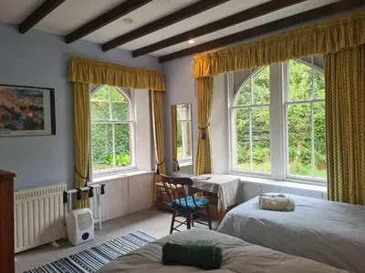 a bedroom with two beds and two windows at North Lodge of Orchil in Braco