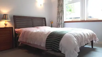 a bedroom with a bed and a window at North Lodge of Orchil in Braco