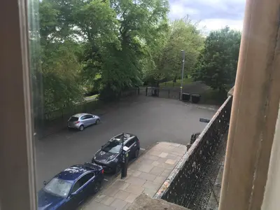 two cars parked in a parking lot from a window at Grand in the Park in Glasgow