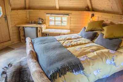 a bedroom with a bed in a log cabin at Little Lochan Lodge in Glenfarg
