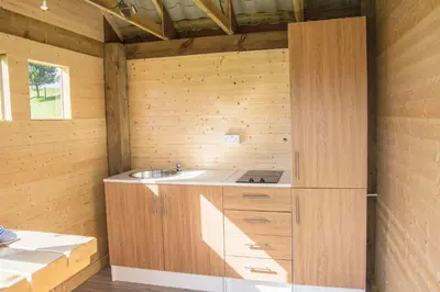 a kitchen with a sink in a wooden wall at Little Lochan Lodge in Glenfarg