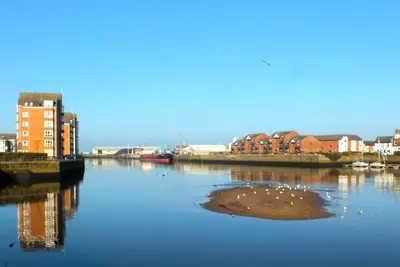 a body of water with some buildings and houses at Kintyre Apartment in Ayr
