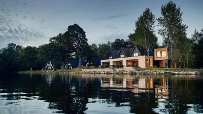 a house on the shore of a body of water at Lochend Chalets in Port of Menteith