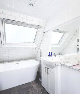 a white bathroom with a tub and a sink at Lochend Chalets in Port of Menteith