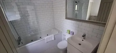 a bathroom with a tub and a toilet and a sink at Lochend Chalets in Port of Menteith