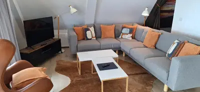a living room with a couch and a tv at Lochend Chalets in Port of Menteith