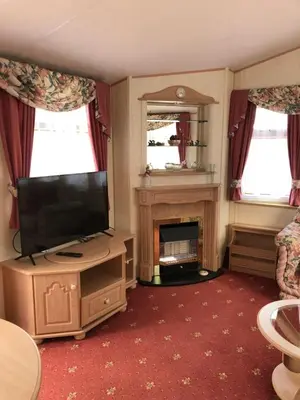 a living room with a television and a fireplace at Lyndhurst 28 in Dunoon