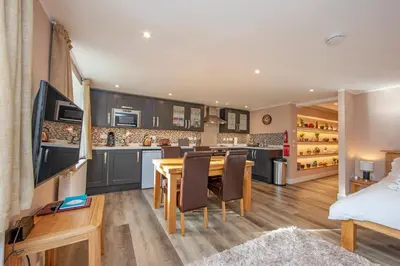 a kitchen and dining room with a table and chairs at Mandarin Premier Apartments C - studio apt in Oban