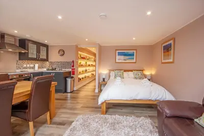 a bedroom with a large bed and a kitchen at Mandarin Premier Apartments C - studio apt in Oban