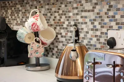 a kitchen counter with a tea kettle and a toaster at Mandarin Premier Apartments C - studio apt in Oban