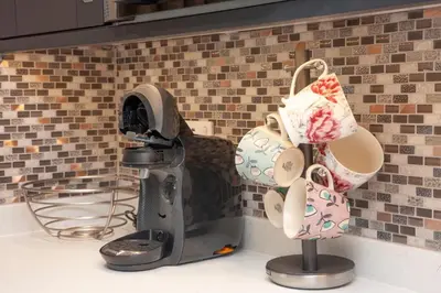a faucet with two pairs of shoes hanging from it at Mandarin Premier Apartments C - studio apt in Oban