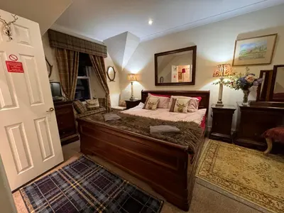 a bedroom with a large bed and a mirror at The West Highland Way Campsite & Campervan Accommodation in Milngavie