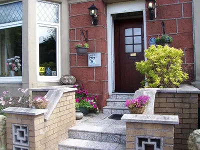 a house with flowers in front of a door at Sunnyside B&B in Balloch