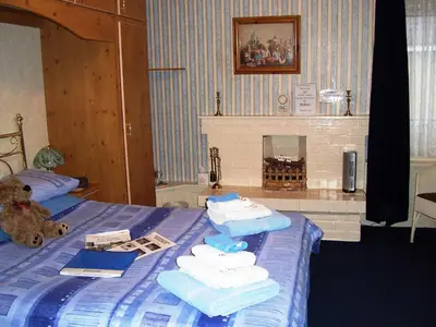 a bedroom with a bed with towels and a fireplace at Sunnyside B&B in Balloch