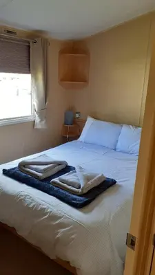 a bedroom with a bed with two towels on it at Fairways 21...Turnberry in Girvan