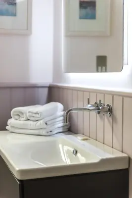 a bathroom with a sink and a mirror and towels at Amazing penthouse, stunning views, Castle 2 mins in Edinburgh