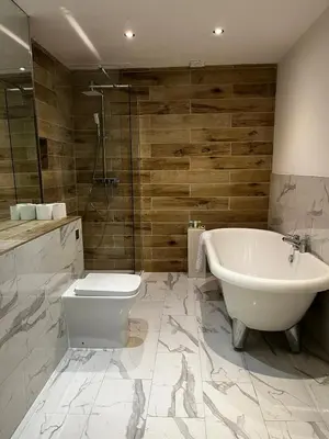 a bathroom with a tub and a toilet and a sink at WEST END -Stunning, 2 bedroom, main door flat with private parking in Glasgow