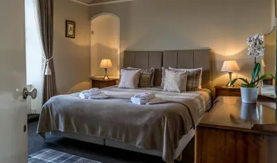a bedroom with a large bed with towels on it at The Tregortha B&B in Tighnabruaich