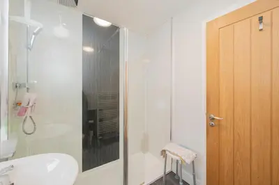 a bathroom with a shower and a toilet and a sink at The Lodge House Callander in Callander