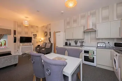 a kitchen and living room with a table and chairs at The Lodge House Callander in Callander