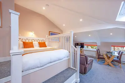 a bedroom with a white bed and a desk at Mandarin Premier Apartments B - Loft studio apt in Oban