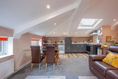a kitchen and living room with a couch and a table at Mandarin Premier Apartments B - Loft studio apt in Oban